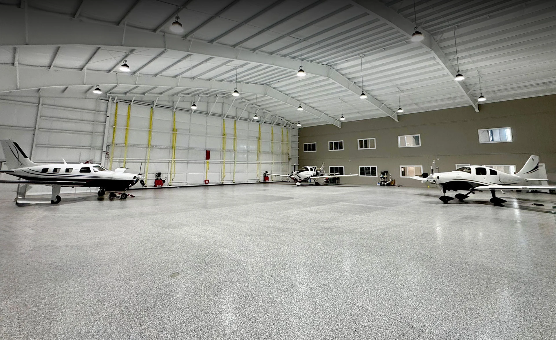 Interior of heated private aircraft hangar at KLXT with turboprops parked